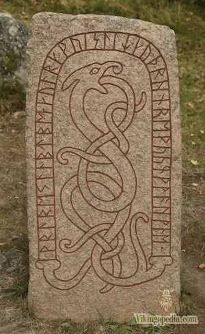 Antigua piedra rúnica vikinga tallada con motivos de serpientes entrelazadas